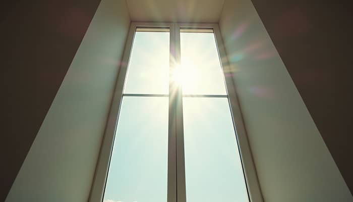 Eye-level view of a window with clear glass and sunlight streaming through Eye-level view of a window with clear glass and sunlight streaming through